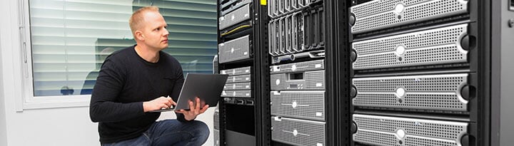 consultant using a laptop while monitoring server consultant using a laptop while monitoring server