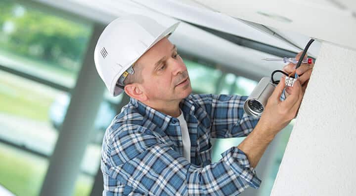 man installing a security camera system man installing a security camera system