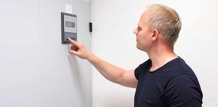 Man-Performs-Security-System-Maintenance Man Performs Security System Maintenance