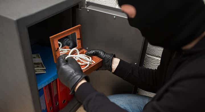 thief stealing valuables from safe thief stealing valuables from safe