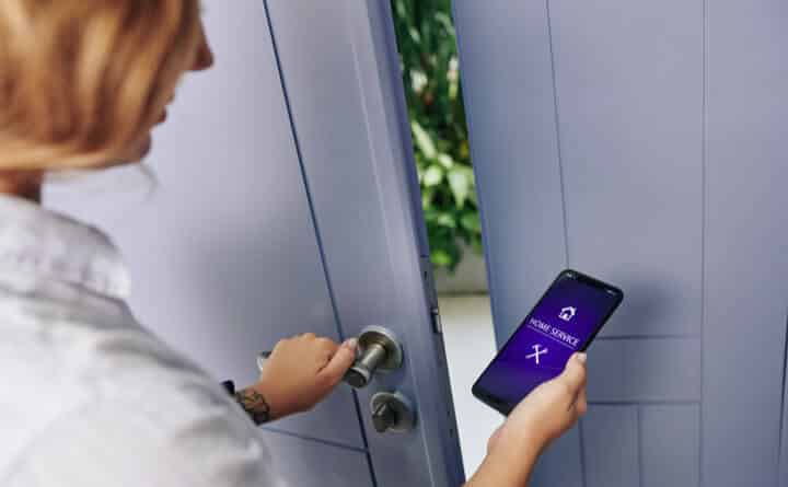 woman using home service application to open the door woman using home service application to open the door